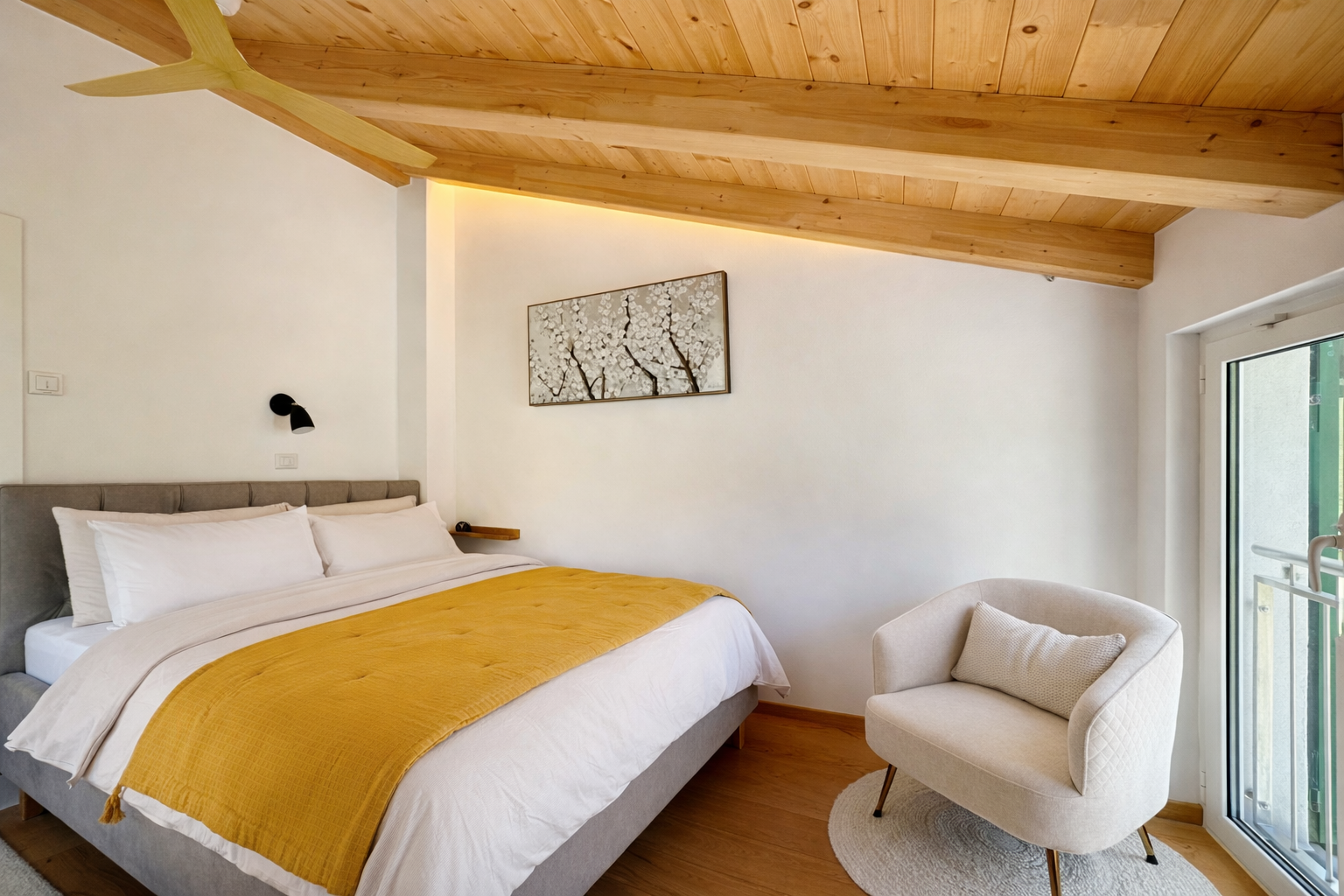 Bedroom with double bed, wooden ceiling and cosy seating area