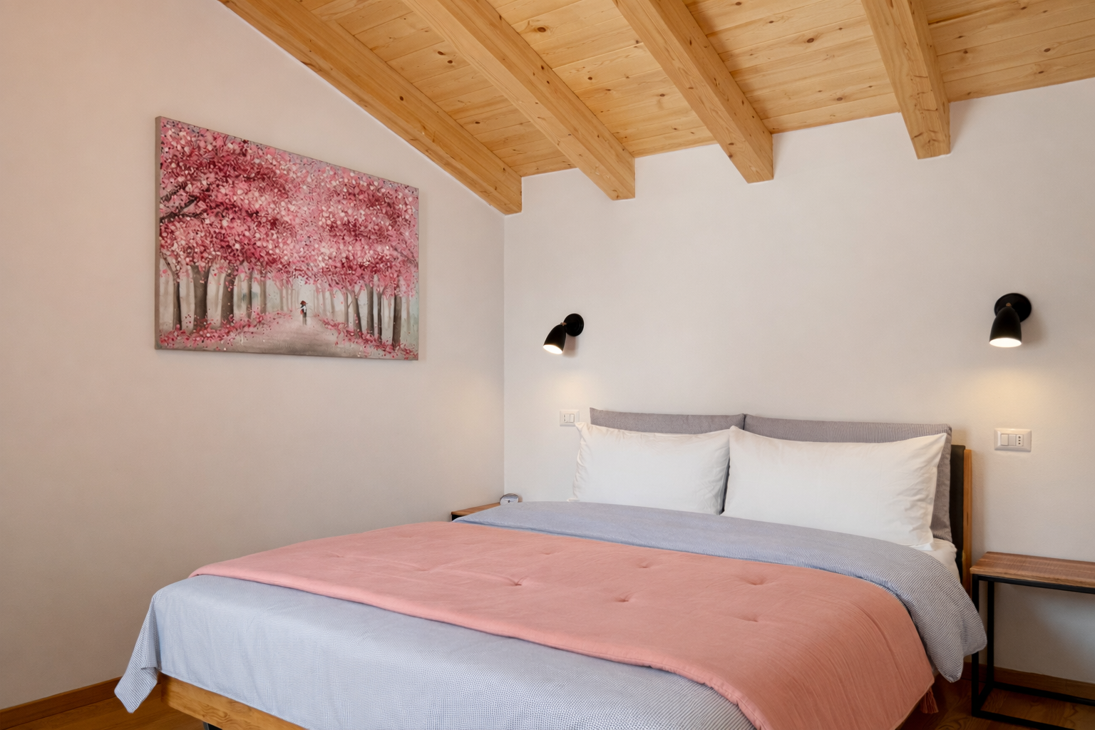 Bedroom with double bed, pink bedspread and wooden ceiling.