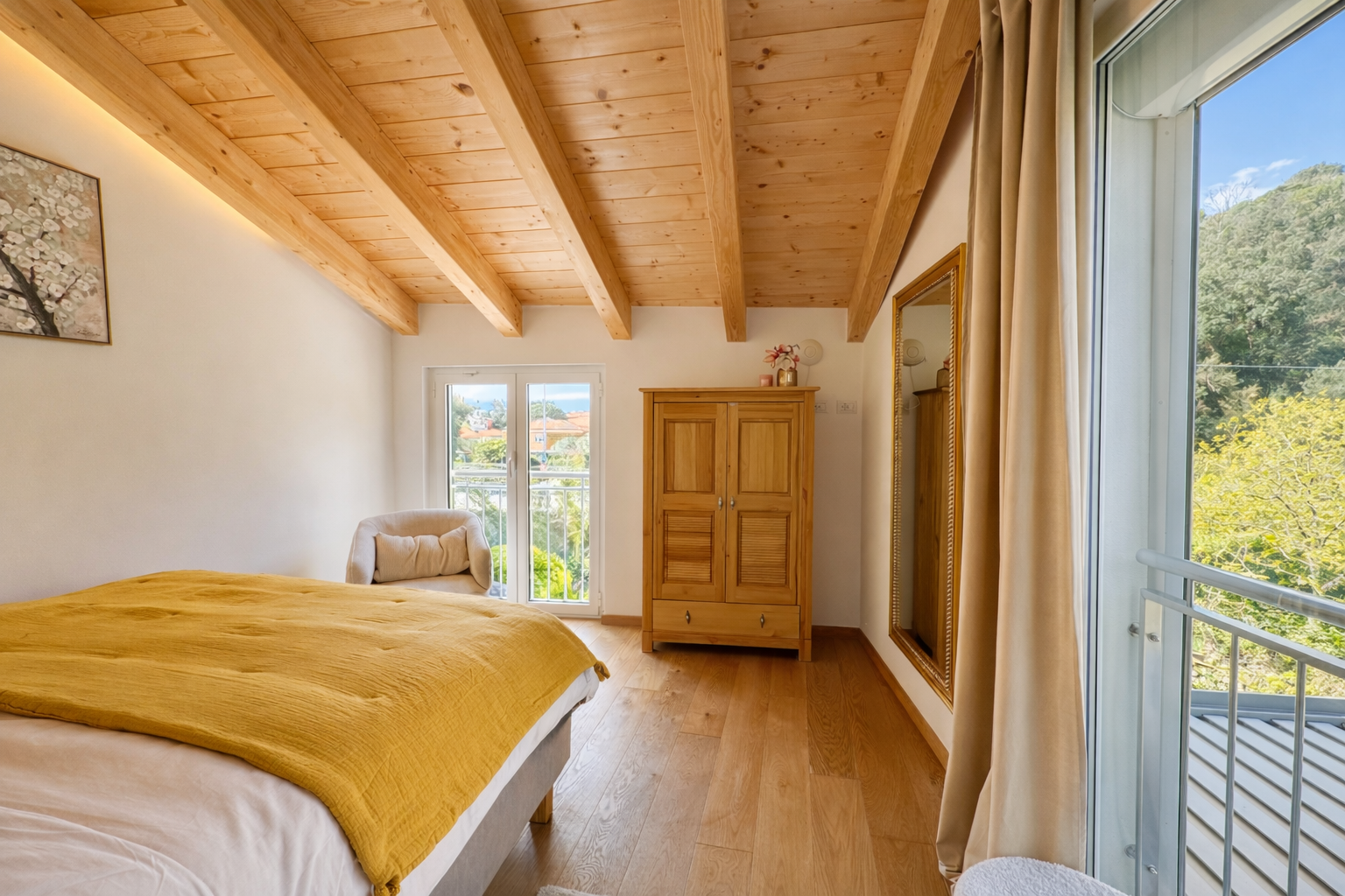 Bedroom with double bed, wooden ceiling and access to the balcony