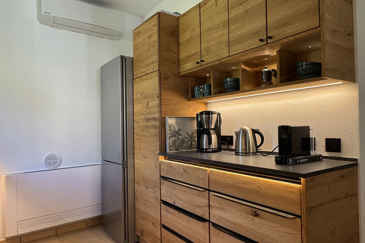 Kitchen with wooden cabinets, fridge and coffee machine